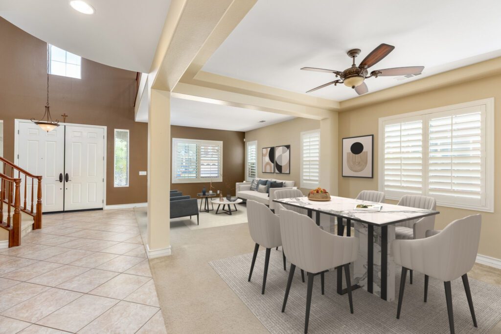Spacious living and dining area featuring a modern dining table, plush chairs, and ample natural light from large windows.