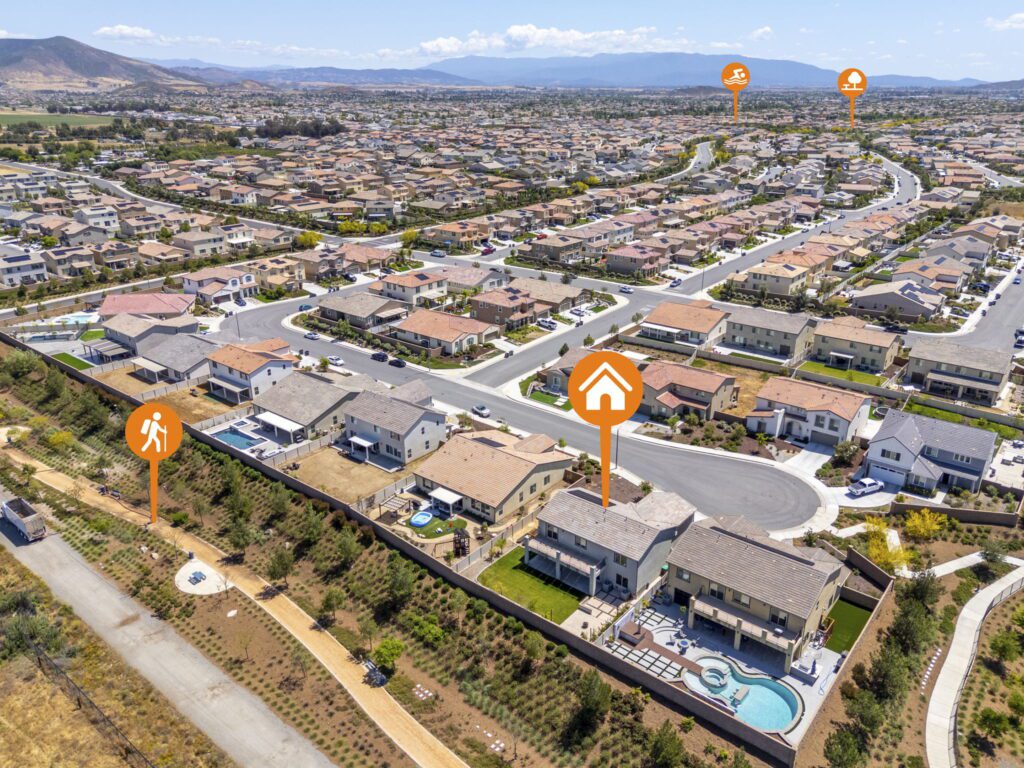 Aerial view of a suburban neighborhood featuring houses, a pool, and walking paths, with markers indicating local amenities like parks and trails.